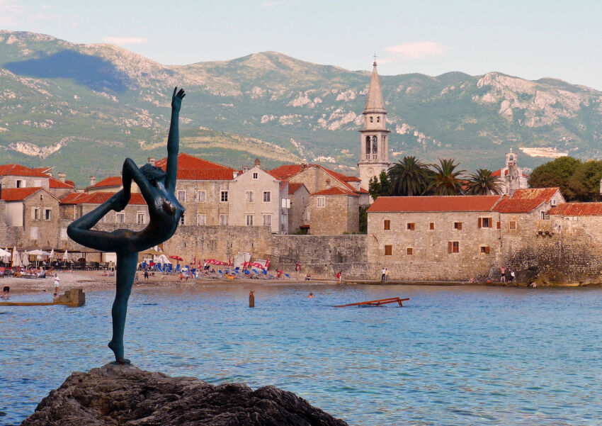 Statua Plesačice na pozadini Starog grada u Budvi, Crna Gora